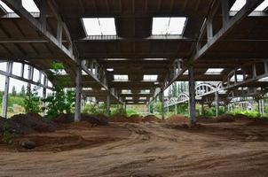 Landscape image of an abandoned industrial hangar with a damaged roof. Photo on wide-angle lens