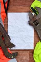 Adjustable wrenches and paper lies of an orange and green signal worker shirts photo