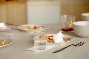 platos sucios vacíos con cucharas y tenedores en la mesa después de la comida. concepto de final de banquete. platos sin lavar foto