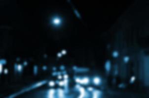 escena nocturna borrosa de tráfico en la carretera. imagen desenfocada de coches que viajan con faros luminosos. arte bokeh foto