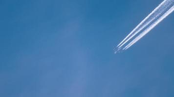 contrails in de blauwe lucht. vliegtuig dat hoog vliegt. video