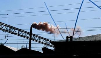 humo de la chimenea de una planta química contra el cielo azul. el problema de la contaminación ambiental. concepto de ecología foto