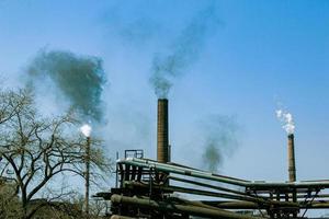 humo de la chimenea de una planta química contra el cielo azul. el problema de la contaminación ambiental. concepto de ecología foto