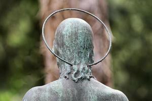 Detrás de una figura de Jesús con un halo en un cementerio contra un fondo borroso foto