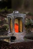 Funeral lantern in a cemetery at dusk with a burning candle photo