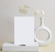 vista frontal de la tarjeta de felicitación y flor seca en jarrón de cerámica sobre la mesa foto