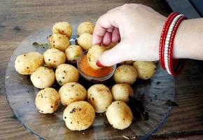 Suji appe or rice appe or appam, an Indian snack with onion, peanuts and tamarind dip photo