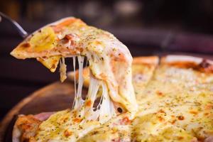 pizza hawaiian cheese on wood table. homemade food concept photo