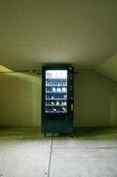 vending machine, with interior light, wall, ceiling and concrete floor photo