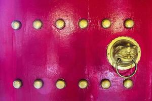 Lion head door knocker on a chinese red door photo