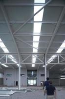 two people walking, in an industrial building repair, all white, steel column, steel beams repair photo