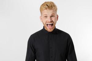 Excited surprised shock young shouting man isolated on gray background. Happy Redhead guy with red beard in black stylish shirt. Success and pass exam concept. Copy space. Close up of Face expression. photo