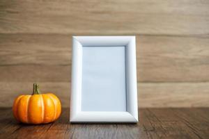 calabaza naranja en la mesa y el marco con espacio para copiar texto. feliz día de halloween, hola octubre, temporada de otoño, concepto festivo, fiesta y vacaciones foto