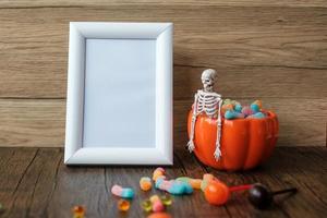 tazón de calabaza naranja y dulces en la mesa y el marco con espacio para copiar texto. feliz día de halloween, hola octubre, temporada de otoño, concepto festivo, fiesta y vacaciones foto