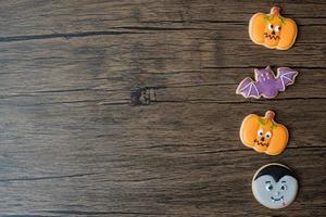 feliz día de halloween con galletas divertidas sobre fondo de mesa de madera. truco o amenaza, hola octubre, otoño otoño, festivo, fiesta y concepto de vacaciones foto