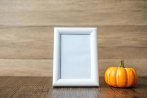 calabaza naranja en la mesa y el marco con espacio para copiar texto. feliz día de halloween, hola octubre, temporada de otoño, concepto festivo, fiesta y vacaciones foto