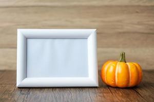 Orange pumpkin on table and frame with copy space for text. Happy Halloween day, Hello October, fall autumn season, Festive, party and holiday concept photo