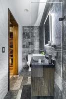 bathroom with luxury finishes, main mirror with led light from behind, white ceramic washbasin photo
