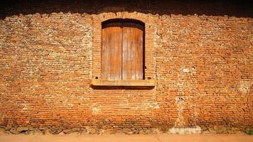 antigua puerta de madera en una pared de ladrillo, venta de madera y pared de ladrillo, pared envejecida, madera rota foto