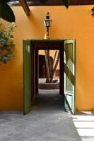 Old house, painted orange, with wooden door painted in green photo