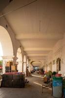 colonial architecture, arches surrounded by vegetation, play of light and shadows inside the space, natural materials photo