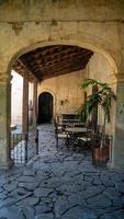 colonial architecture, arches surrounded by vegetation, play of light and shadows inside the space, natural materials photo