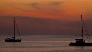toneel- visie van een zonnig zonsondergang in de zee. silhouetten van boten Aan de achtergrond van de zonsondergang. reizen naar de zee video