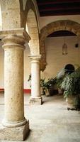 colonial architecture, arches surrounded by vegetation, play of light and shadows inside the space, natural materials photo