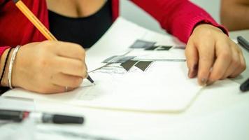 persona dibujando a mano con pluma, lápiz y tinta, perspectivas arquitectónicas, en color. foto