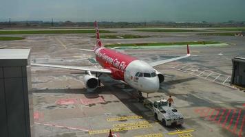 Changi, Singapour 25 novembre 2018 - véhicule tracteur pousse un Airbus A320 d'airasia depuis le terminal avant le décollage à l'aéroport de Changi, Singapour video