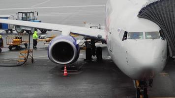 NOVOSIBIRSK, RUSSIAN FEDERATION JULY 24, 2021 - Airport staff unloading luggage. Boeing 737 of SmartAvia at Tolmachevo airport, Novosibirsk. video