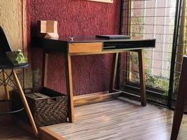 wooden desk with chair, plants in the room, natural sunlight coming in, pasta tile floor, white painted walls photo