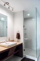 bathroom with luxury finishes, main mirror with led light from behind, white ceramic washbasin photo