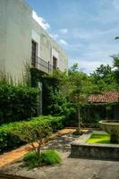 colonial architecture, arches surrounded by vegetation, play of light and shadows inside the space, natural materials photo