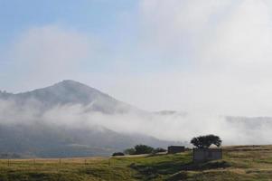 abandoned house on a hill, unfinished building, with mountains photo