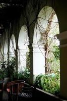 colonial architecture, arches surrounded by vegetation, play of light and shadows inside the space, natural materials photo
