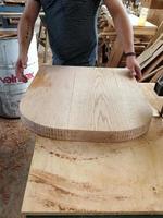 A man cuts wood on a circular saw in a joinery, band saw, holding a plank photo