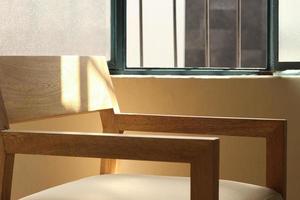 A chair modern wood frame with wooden, sunlight coming through the window illuminating the chair photo