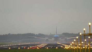 AMSTERDAM, THE NETHERLANDS JULY 28, 2017 - Slow motion shot of braking jet liner, rear view from end of runway. Passenger plane touch ground. Evening time shot of Amsterdam Airport air traffic video