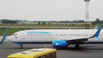 novosibirsk, federación rusa 24 de julio de 2021 - vista desde la ventana de la terminal hasta la calle de rodaje de un boeing 737 de pobeda airlines video