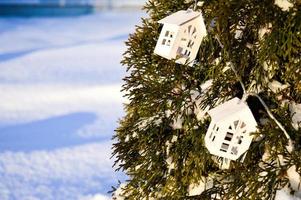 árbol de navidad con decoración colgante de casa en miniatura foto