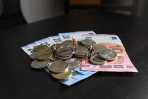 Miniature figurines of worker working on a pile of money photo