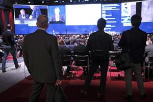 London, UK, 2019 - Audience members at a conference follow the presentation on stage photo