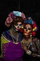 Closeup portrait of a woman with a sugar skull makeup dressed with flower crown. Halloween concept photo