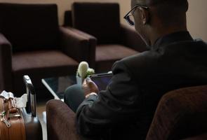 Businessman working on tablet PC at airport lounge photo