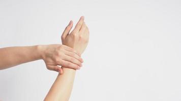 Male model is rub wrist to mid-upper arm in a rotating manner on white background. photo