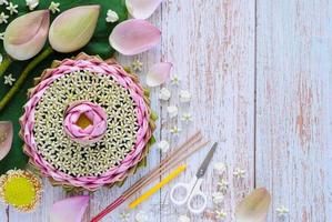 krathong de pétalos de loto rosa para tailandia festival loy krathong hecho de loto y flor de corona con incienso y vela sobre fondo de madera. foto