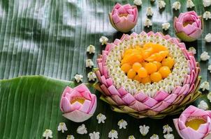 Thai wedding desserts on plate or krathong made from pink lotus petal and crown flower for thai traditional ceremony on banana leaf background.