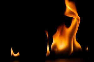 poder ardiente de la llama, llamas y chispas ardientes de cerca, patrones de fuego, el resplandor del fuego en la oscuridad foto