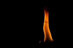poder ardiente de la llama, llamas y chispas ardientes de cerca, patrones de fuego, el resplandor del fuego en la oscuridad foto